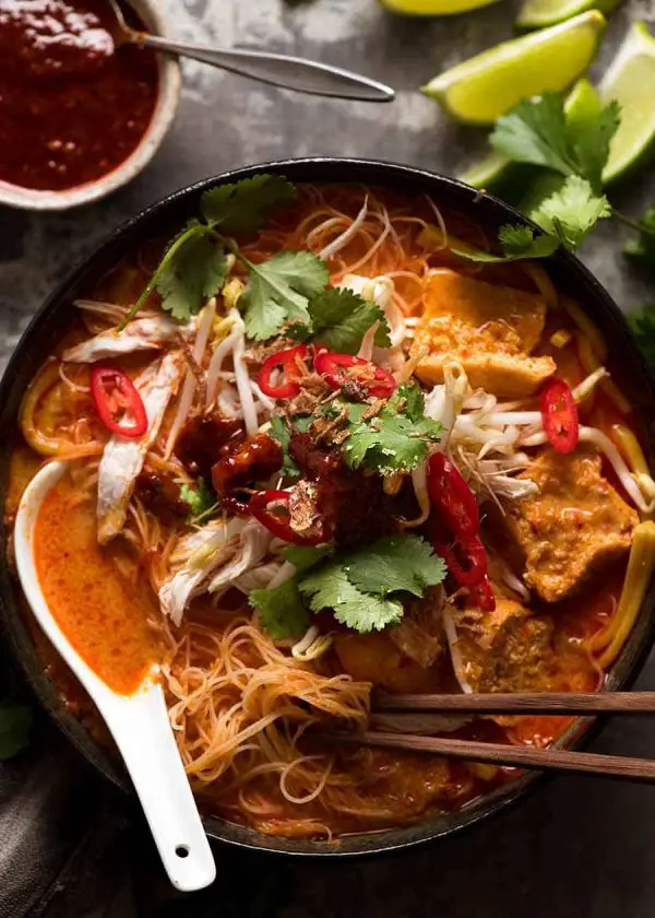 Overhead photo of Laksa in a rustic bowl, ready to be eaten.